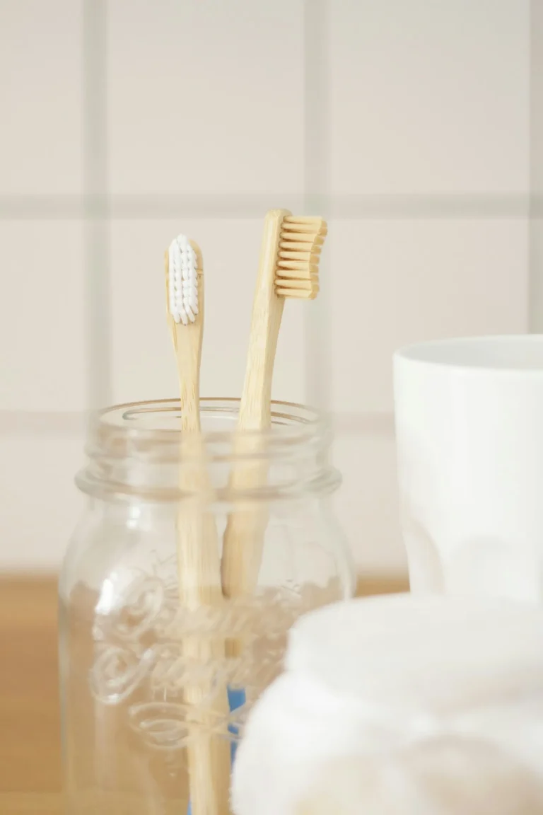 Two bamboo toothbrushes on a plain background